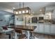 Open-concept kitchen with a dining area and a modern lighting fixture over a large, wooden table at 758 Claudia Ln, Palm Harbor, FL 34683