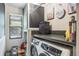 Functional laundry room with front-load washer/dryer, storage, and a bright window at 758 Claudia Ln, Palm Harbor, FL 34683