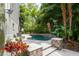 Backyard pool area has lovely tropical landscaping and a water feature, creating a private oasis at 758 Claudia Ln, Palm Harbor, FL 34683