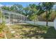Backyard view of screened-in pool with stepping stones to fenced yard at 7606 S Sparkman St, Tampa, FL 33616