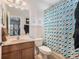 Bathroom with a single vanity, modern shower curtain, and framed art adding a touch of personality at 7606 S Sparkman St, Tampa, FL 33616