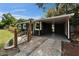 Open carport featuring a concrete floor, wood accent wall, and direct access to the home's entrance at 901 King St, Plant City, FL 33563