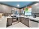 Updated kitchen features stainless steel appliances, white countertops, and stylish gray cabinetry at 901 King St, Plant City, FL 33563