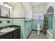 Bathroom featuring original green tiling, decorative flooring, a bathtub, and sink with vanity at 933 E Shadowlawn Ave, Tampa, FL 33603