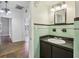 A bathroom with green tile, a black vanity, and a mirror hanging above the sink at 933 E Shadowlawn Ave, Tampa, FL 33603