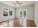 Bright bedroom with hardwood floors, ceiling fan, two windows, and glass panel doors at 933 E Shadowlawn Ave, Tampa, FL 33603