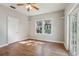 Bright bedroom with hardwood floors, ceiling fan, two windows, and glass panel doors at 933 E Shadowlawn Ave, Tampa, FL 33603