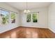 A spacious dining room featuring hardwood floors, a chandelier, and natural light from windows at 933 E Shadowlawn Ave, Tampa, FL 33603