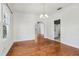 A spacious dining room featuring an arched doorway, hardwood floors, and a chandelier at 933 E Shadowlawn Ave, Tampa, FL 33603