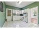 Traditional kitchen featuring white appliances and cabinets with a window above the sink at 933 E Shadowlawn Ave, Tampa, FL 33603