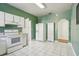 A spacious kitchen with white appliances, white tile floors, and green painted walls at 933 E Shadowlawn Ave, Tampa, FL 33603
