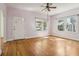 Bright living room features hardwood floors, two large windows, and white door at 933 E Shadowlawn Ave, Tampa, FL 33603