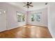 Bright living room features hardwood floors, two large windows, and white door at 933 E Shadowlawn Ave, Tampa, FL 33603