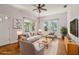 Bright living room with two windows, a ceiling fan, and hardwood flooring at 933 E Shadowlawn Ave, Tampa, FL 33603