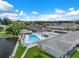 Aerial view showcases the community pool, surrounding landscaping, and proximity to a serene pond at 10008 Daffodil N St # 186, Pinellas Park, FL 33782