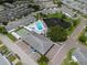 Aerial view showcasing community amenities: swimming pool, shuffleboard courts, pond, and resident parking at 10008 Daffodil N St # 186, Pinellas Park, FL 33782