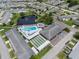 Aerial view features a community pool, shuffleboard courts, pond, and surrounding residential properties at 10008 Daffodil N St # 186, Pinellas Park, FL 33782