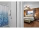 Updated bathroom with shower and tub combo next to the bedroom with ceiling fan and wood paneling at 10008 Daffodil N St # 186, Pinellas Park, FL 33782