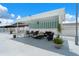 Covered cabana lounge area with comfortable seating surrounded by lush tropical plants and a white picket fence at 10008 Daffodil N St # 186, Pinellas Park, FL 33782