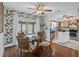Cozy dining area with tropical wallpaper and glass table, seamlessly flowing into the updated kitchen at 10008 Daffodil N St # 186, Pinellas Park, FL 33782
