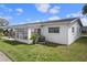 View of the house showing the sunroom addition, air conditioner unit, and well-maintained landscaping at 10008 Daffodil N St # 186, Pinellas Park, FL 33782
