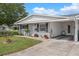 Well-maintained home with a lush front lawn and attached carport providing covered parking and storage at 10008 Daffodil N St # 186, Pinellas Park, FL 33782