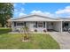 Charming single-story home featuring a well-manicured lawn, gray brick facade, and a convenient carport at 10008 Daffodil N St # 186, Pinellas Park, FL 33782