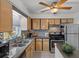 Bright kitchen featuring stainless steel appliances, mosaic backsplash, and plenty of cabinets at 10008 Daffodil N St # 186, Pinellas Park, FL 33782