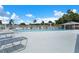Outdoor pool featuring lounge chairs, blue skies, and palm trees create a relaxing community atmosphere at 10008 Daffodil N St # 186, Pinellas Park, FL 33782