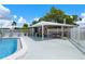 Outdoor poolside patio features a brick building with covered seating and ample space to relax by the pool at 10008 Daffodil N St # 186, Pinellas Park, FL 33782