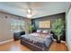 Unique bedroom featuring dark walls, a ceiling fan, a window, and palm trees, exuding style and tranquility at 10404 Crestfield Dr, Riverview, FL 33569