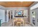 Bright breakfast nook features wood floors, wood ceiling, and a peek into a living area with dark leather couches at 10404 Crestfield Dr, Riverview, FL 33569