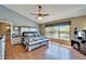 Spacious main bedroom featuring a large window, wood floors, a ceiling fan, and an ensuite bathroom at 10404 Crestfield Dr, Riverview, FL 33569