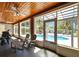 A sun room featuring tile floors, wood ceiling, seating and view of the pool at 10404 Crestfield Dr, Riverview, FL 33569