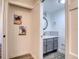 Charming bathroom entrance featuring a white vanity with marble countertop and decor art at 1111 N Bayshore Blvd # E3, Clearwater, FL 33759