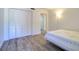 Bedroom with wood floors, a lamp, closet doors and a glimpse into the adjacent bathroom at 1111 N Bayshore Blvd # E3, Clearwater, FL 33759