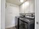 This laundry room features a front loading washer and dryer, white cabinets, and a bright overhead light at 1111 N Bayshore Blvd # E3, Clearwater, FL 33759