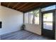 Relax on this screened in patio with views of a palm tree and plank flooring at 1111 N Bayshore Blvd # E3, Clearwater, FL 33759