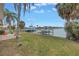 Waterfront backyard with lush lawn and private dock overlooking the serene canal, perfect for boating enthusiasts at 11755 7Th E St, Treasure Island, FL 33706