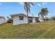 Expansive backyard featuring a view of the waterfront, framed by mature palm trees and an inviting patio at 11755 7Th E St, Treasure Island, FL 33706