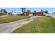 Charming single-story home featuring a stone facade and red tile roof, complemented by a spacious driveway and lush front yard at 11755 7Th E St, Treasure Island, FL 33706