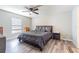 Bedroom with wood-look flooring featuring a ceiling fan and a bed with an upholstered headboard at 12639 Lemon Pepper Dr, Riverview, FL 33578