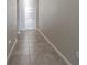 Clean, tiled hallway with a neutral color palette and ample lighting at 12639 Lemon Pepper Dr, Riverview, FL 33578