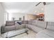 Comfortable living room featuring a large sectional sofa, glass coffee table, and an open layout leading to the kitchen at 12639 Lemon Pepper Dr, Riverview, FL 33578