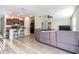 Spacious living room with tile flooring, gray sectional, and open access to a kitchen with bar seating at 12639 Lemon Pepper Dr, Riverview, FL 33578