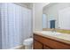 This bathroom features a bathtub with a shower, and a vanity with brown cabinets at 14426 Haddon Mist Dr, Wimauma, FL 33598