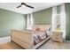 Comfortable bedroom boasts neutral carpet, soft green walls, and two windows with sheer curtains at 14426 Haddon Mist Dr, Wimauma, FL 33598