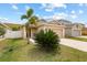 Charming single-Gathering home with manicured front lawn, palm tree, and two-car garage at 14426 Haddon Mist Dr, Wimauma, FL 33598