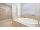 Bright bathroom showcasing a walk-in shower with glass door and a separate soaking tub at 14809 Tudor Chase Dr, Tampa, FL 33626