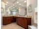 This large bathroom features a double sink vanity with granite countertops and a huge mirror at 14809 Tudor Chase Dr, Tampa, FL 33626